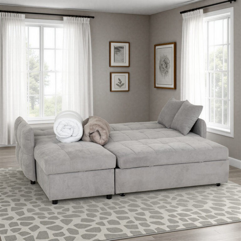 Gray sectional sofa in a living room with large windows and framed artwork on the wall.