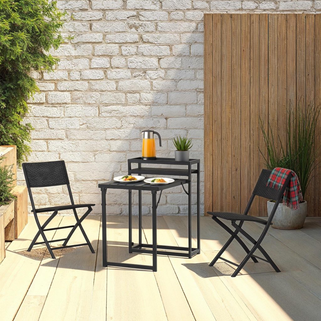 Outdoor patio set with two black folding chairs and a small table against a stone wall.