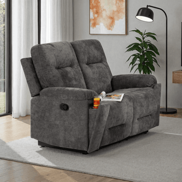 Gray recliner sofa in a living room setting with a magazine and drink on it.