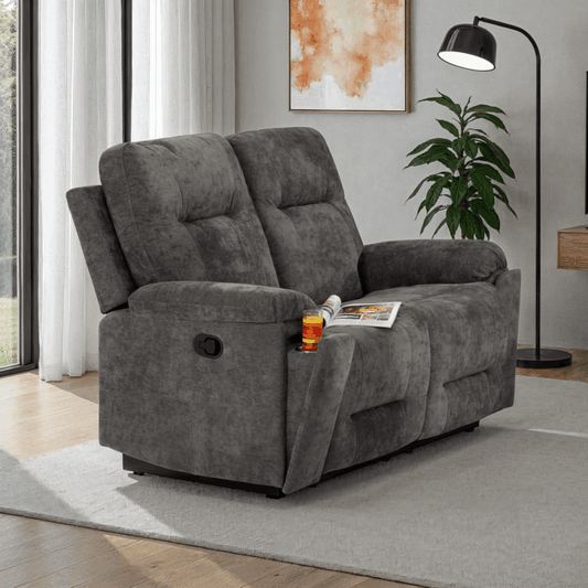 Gray recliner sofa in a living room setting with a magazine and drink on it.