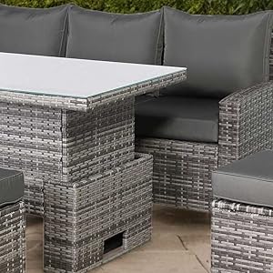 Outdoor furniture set with wicker chairs and table against a gray wall.