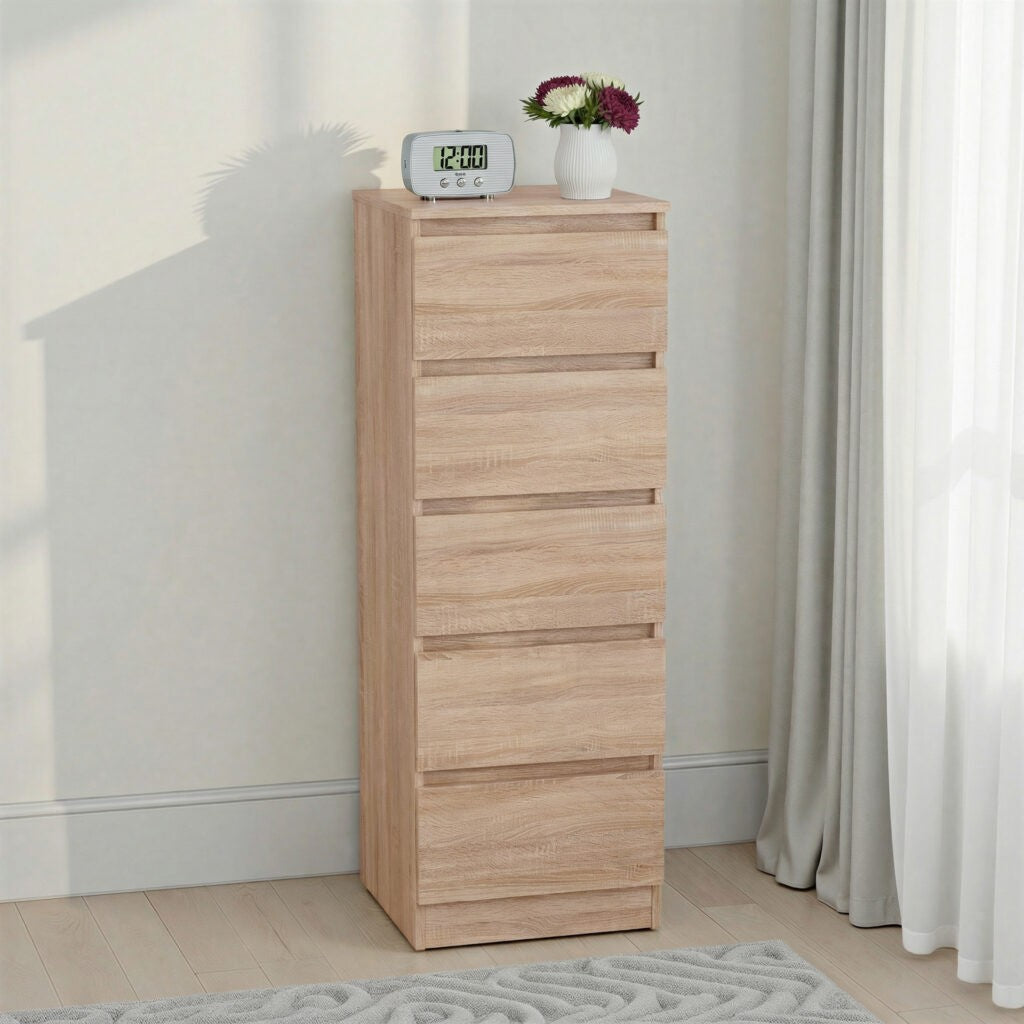 Malvern 5 Drawer Narrow Chest – Sonoma Oak Effect with drawers against a white wall, featuring a digital clock and small plant on top.