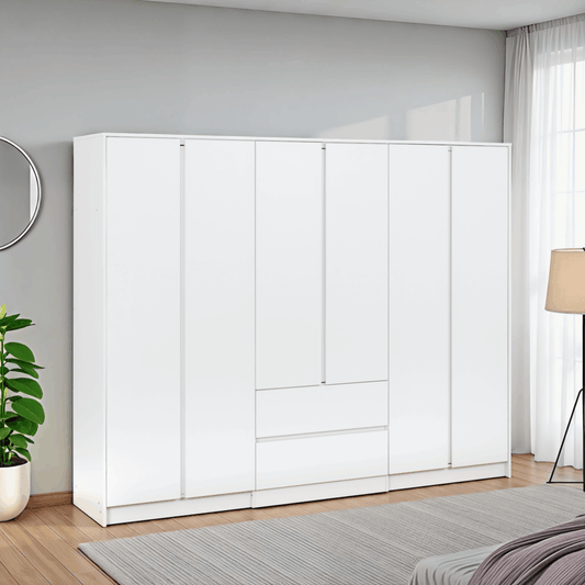 Malvern 6 Door 2 Drawer Wardrobe - White in a bedroom with a plant and lamp in the foreground