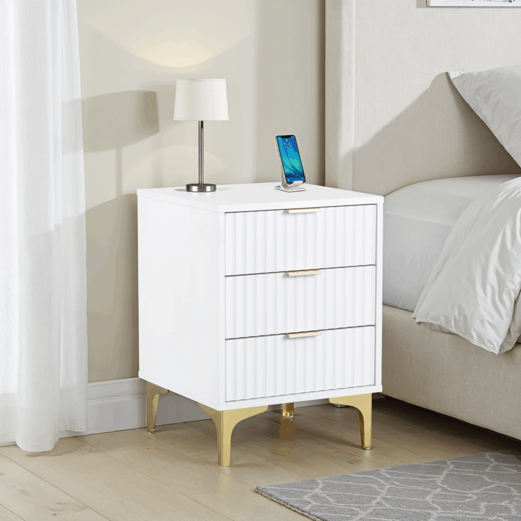 White nightstand with gold legs next to a bed in a bedroom setting