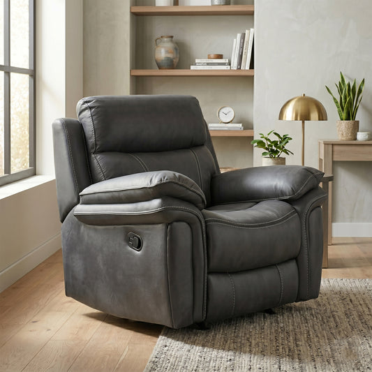 A dark gray upholstered recliner chair shown in a styled living room with wood flooring, built-in shelves, plants, a side table, and a gold floor lamp.
