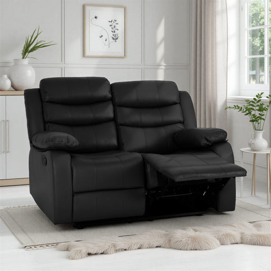 Black leather recliner sofa in a living room setting with plants and decor.