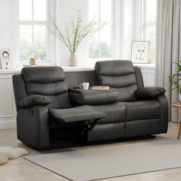 Gray reclining sofa in a living room with plants and decor.