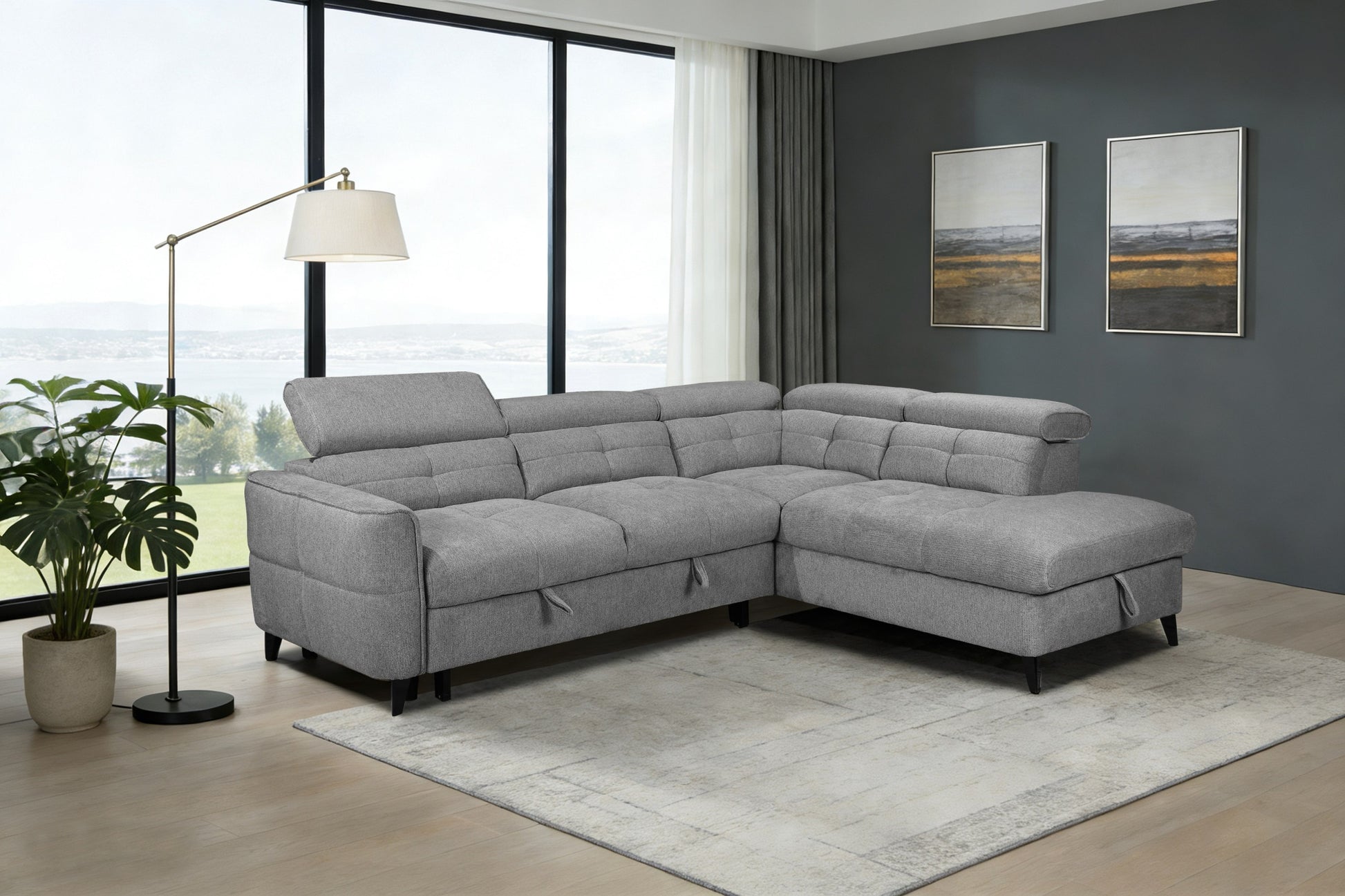 Gray sectional sofa in a living room with large windows and decorative elements.