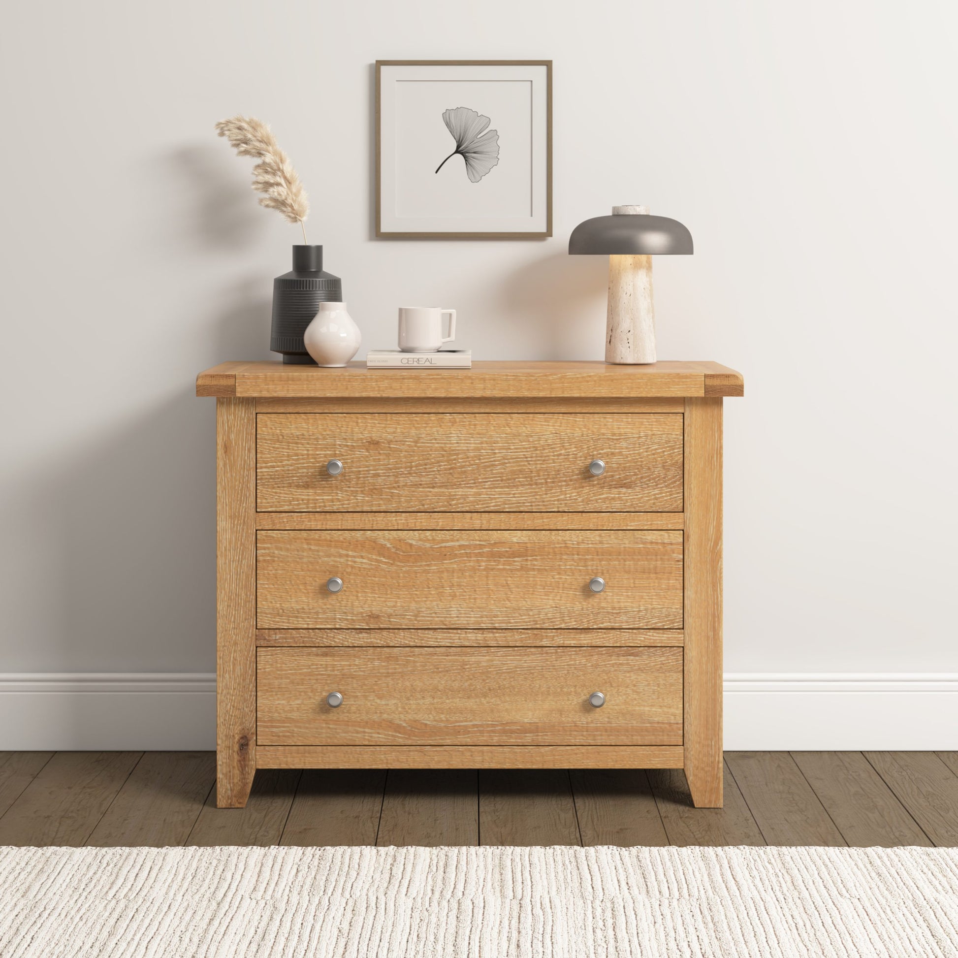 Wooden dresser with three drawers in a room setting with decor items on top.