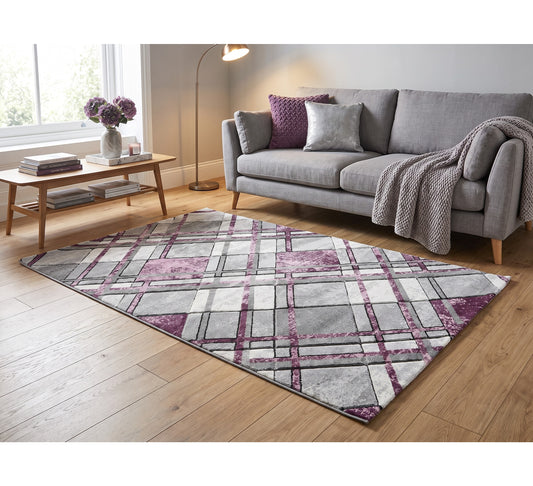 Accra grey and lilac geometric rug on a wooden floor in front of a grey sofa