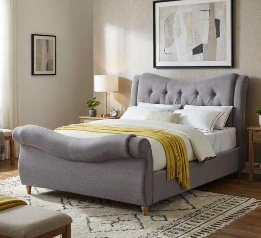 Arizona grey upholstered sleigh bed with a yellow throw in a bedroom with a patterned rug