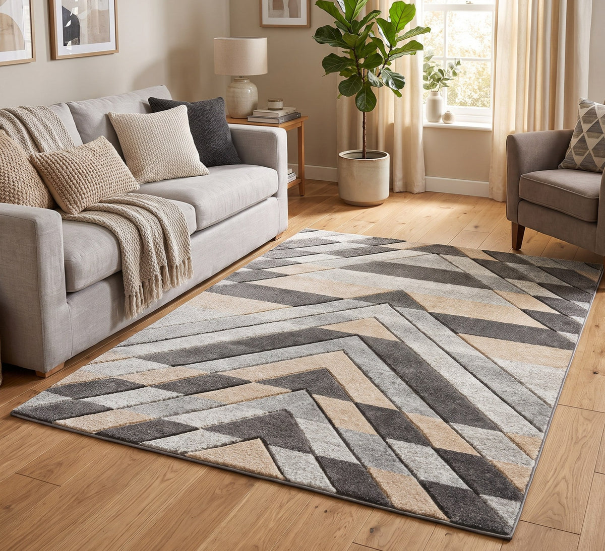 Asher grey and beige chevron rug in a living room beside a grey sofa and armchair