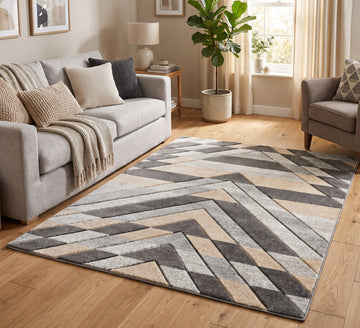 Asher grey and beige chevron rug in a living room beside a grey sofa and armchair