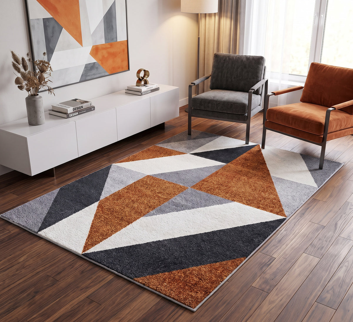 Aspire Rug - 106, orange, grey and white triangle-pattern rug beside dark and orange armchairs on a wooden floor