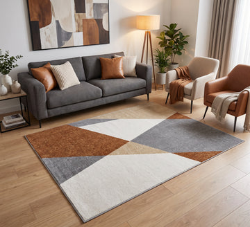 Aspire Rug - 107, rust, grey and cream geometric rug beside a grey sofa on a wooden floor