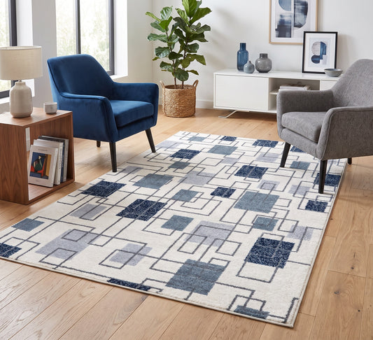 Aspire Rug - Blue, blue square-pattern rug between navy and grey armchairs on a wooden floor
