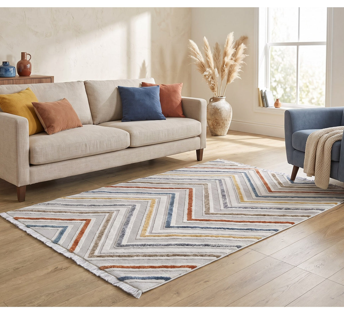 Broadway Rug - 5008A, chevron-pattern rug between a cream sofa and navy armchair