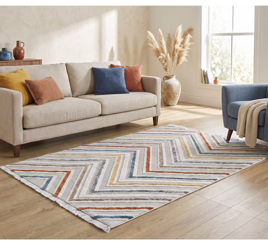 Broadway Rug - 5008A, chevron-pattern rug between a cream sofa and navy armchair
