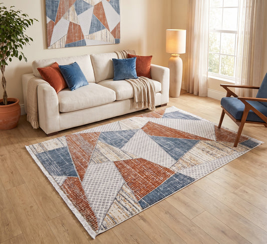 Broadway Rug - 5293A, triangle-pattern rug beside a cream sofa and blue armchair