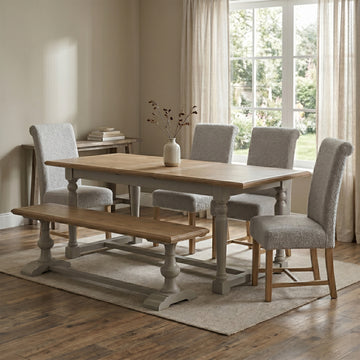Chateau grey painted extending dining table with four chairs and a bench in a room setting