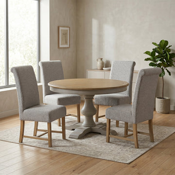 Chateau round dining table and four grey chairs in a room setting