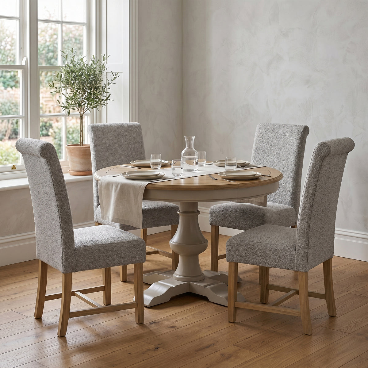 Chateau round dining table with grey chairs in a room setting