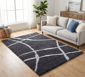 Cruz Rug - Black, black rug with curved cream lines beside a cream sofa