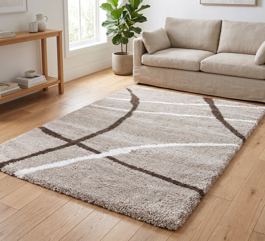 Cruz Rug - Taupe, taupe rug with curved white and brown lines beside a beige sofa