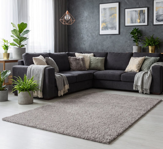 Empire Rug Grey, grey shaggy rug beside a dark corner sofa