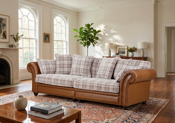 Imperial four-seater brown leather and plaid fabric sofa in a living room with a fireplace