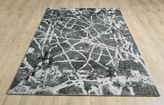 Alisa dark grey and black abstract rug laid flat on a wooden floor