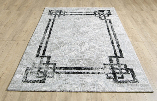 Alisa grey and black rug laid flat on a wooden floor